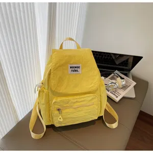 Zaino casual minimalista giallo con tasca frontale, elegante borsa scolastica per donne e studenti.