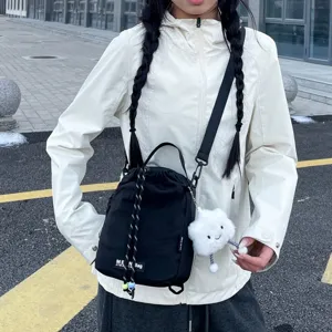Detail view of the black crossbody bag featuring a drawstring closure and cute cloud charm.