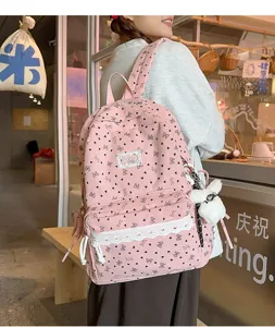 Vista detallada de una mochila rosa con patrón de mariposa y encaje en un modelo