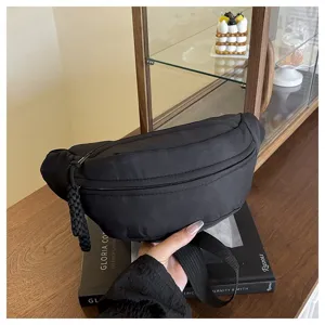 Sac de poitrine minimaliste en nylon noir pour le sport et les loisirs. Sac bandoulière polyvalent.