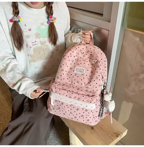 Mochila escolar rosa estética con motivos de corazones, encaje y colgante de peluche.