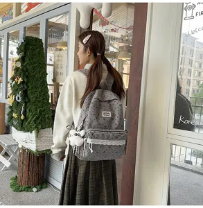 Chica lleva una mochila gris con motivos de estilo escolar en un entorno exterior