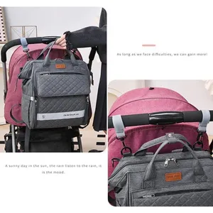 Grauer gesteppter Wickelrucksack Detailansicht mit vielen Fächern und praktischen Kinderwagenriemen.