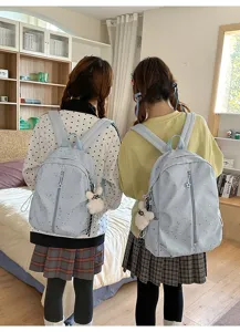 Vista trasera de dos estudiantes con mochilas azul claro con patrones de estrellas