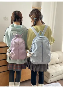 Vista trasera de mochilas estrelladas elegantes azul claro y morado con dijes de conejo
