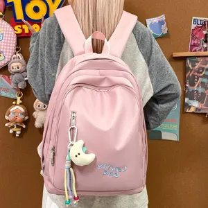 Sac à dos décontracté rose vue détaillée avec joli pendentif lune et poches pratiques.