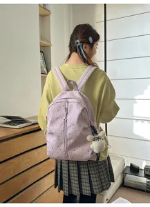 Detalle de la mochila púrpura con patrón de estrellas y colgante de conejo