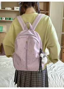 Mochila morada estrellada con patrón de estrellas plateadas y colgante de conejito