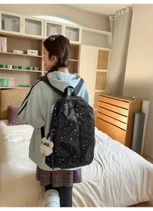 Detalle de mochila negra con diseño de estrellas blancas usada por una chica