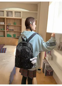 Mochila negra con patrón de estrellas para estudiantes usada en un dormitorio acogedor