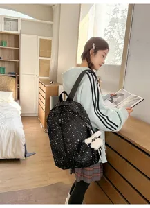 Chica asiática con mochila negra de estrellas y un lindo detalle de colgante de conejo