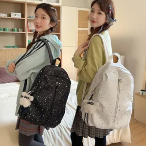 Dos chicas asiáticas con mochilas escolares con diseño de estrellas blanco y negro
