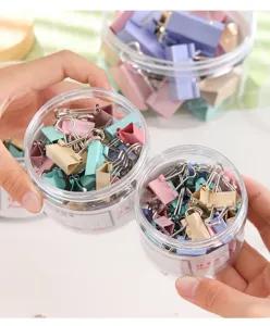 Clips de metal de colores Morandi variados en tarros de almacenamiento transparentes