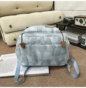 Vue rapprochée d'un sac à dos bleu clair imprimé montrant les détails de texture