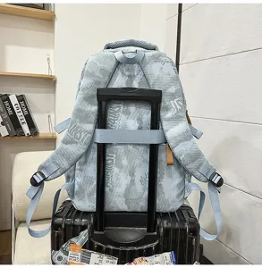 Vue arrière du sac à dos bleu clair avec sangle pour bagages sur valise