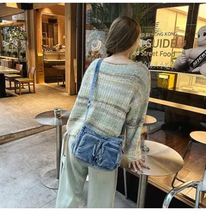 Gedetailleerde opname van een vintage denim schoudertas met meerdere zakken en casual.