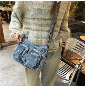 Gedetailleerd overzicht van de stijlvolle gewassen denim schoudertas met diverse voorvakken.