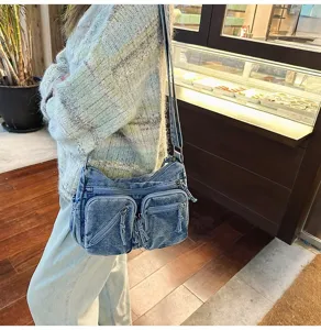 Gedetailleerd overzicht van denim schoudertas met meerdere zakken, casual stijl.