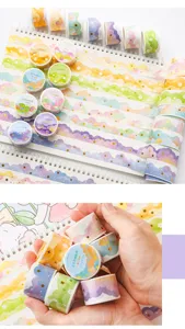Vue détaillée du ruban washi à motif de nuages avec étoiles dorées tenu à la main.
