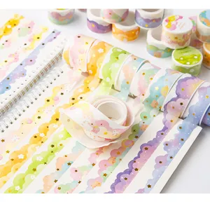 Gros plan sur un ruban washi en forme de nuage avec des motifs d'étoiles dorées pour journal.