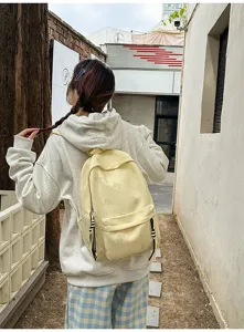 Casual Japanese style backpack with cute butterfly pattern shown in outdoor street setting.