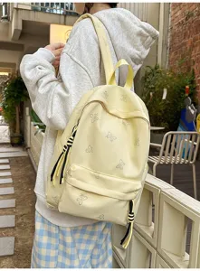 Casual yellow student backpack with cute butterfly pattern and stylish black tassels for daily use.