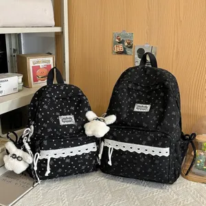 Elegantes mochilas escolares negras para niñas con patrones de corazones y encaje blanco.