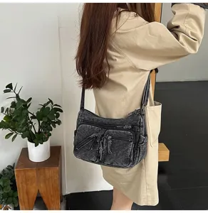 Gedetailleerd overzicht van casual gewassen denim schoudertas met meerdere handige ritsvakken.