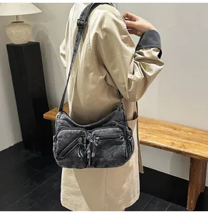 Gedetailleerd overzicht van de stijlvolle gewassen denim schoudertas gedragen door een model.