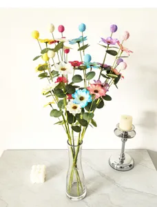 Nahaufnahme eines bunten künstlichen Eukalyptus-Gänseblümchen-Bouquets in Glasvase.