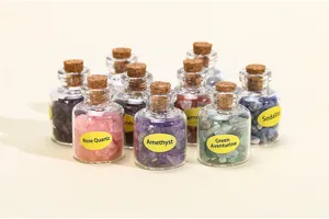 Collection of various natural crystal gemstone chips in small corked glass bottles.