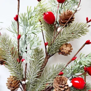 Close-up of artificial pine needles with red berries and pine cones for Christmas decor