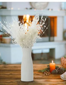 Detailaufnahme von weißen Glitzer künstlichen Weihnachtsblumen und Beeren in Vase.