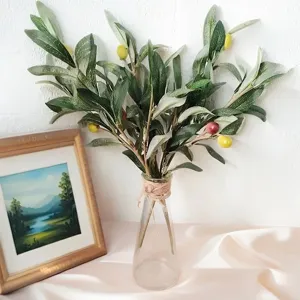 Detailansicht eines künstlichen Olivenzweigs in einer Glasvase für die Heimdekoration