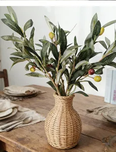 Fausses branches d'olivier avec fruits dans un vase tressé, idéales pour la décoration d'intérieur.