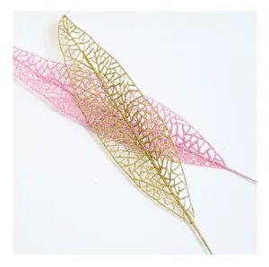Vista dettagliata di foglie traforate decorative con glitter nei colori oro e rosa