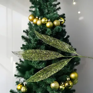Nahaufnahme goldener hohler Pailletten-Weihnachtsblätter als Dekoration am Baum