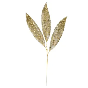 Detailansicht eines goldfarbenen, hohlen Weihnachtsblattes mit glänzenden Pailletten