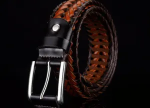 Close-up shot of a hand-woven brown and black leather belt with a silver pin buckle