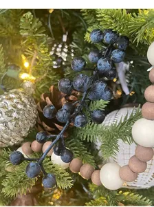 Close-up detail showing the realistic texture of dark blue artificial berry stems for holiday decor
