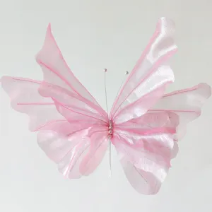 Detailed macro view of a pink sheer gauze artificial butterfly with pearl body accents
