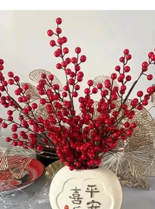 Detailed macro view of artificial red berry branches arranged in a white decorative vase