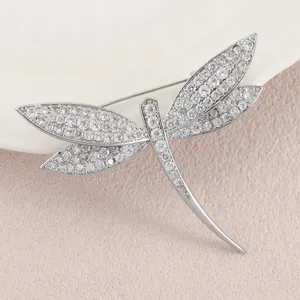 Close-up of a silver-tone dragonfly brooch fully set with sparkling white rhinestones