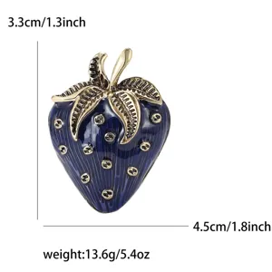Detailed view of a vintage blue enamel strawberry brooch with gold leaf accents