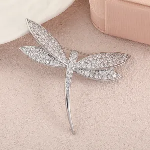 Detailed view of an elegant dragonfly brooch encrusted with shimmering crystals.