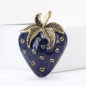 Macro detail of a vintage blue enamel strawberry brooch with gold-toned metal leaves