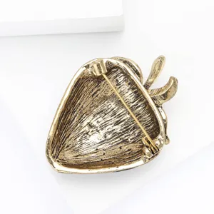 Close-up back view of vintage alloy strawberry brooch with secure pin clasp detail.