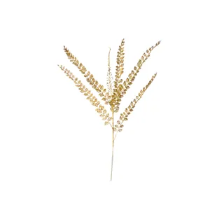 Gold glitter fern plant branch detail closeup, shiny artificial leaf stem for home vase decor.