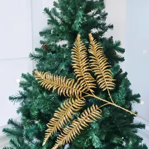 Gros plan d'une branche de fougère persane dorée à 5 pointes pour la décoration de Noël.