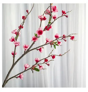 Gros plan d'une branche de fleurs de cerisier artificielles roses et rouges de haute qualité